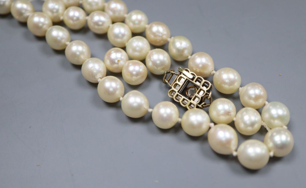 A single strand cultured pearl necklace, with yellow metal and thirteen stone diamond set clasp (strand a.f.).